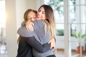 regressar a portugal duas mulheres abraçadas em casa