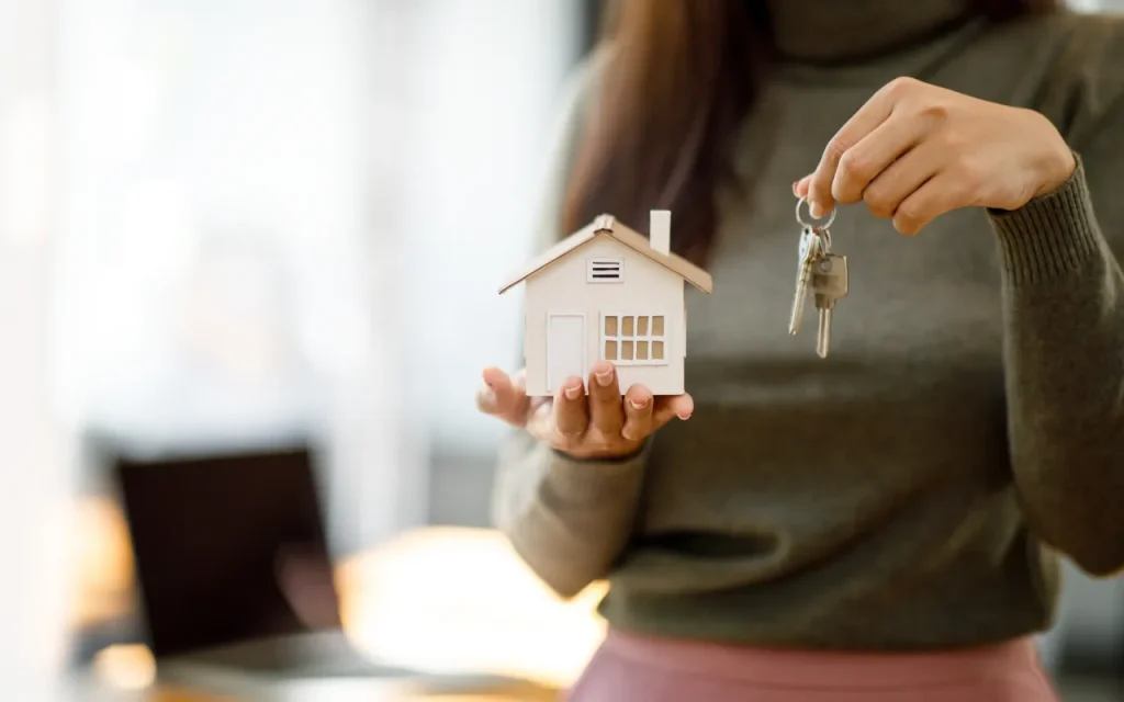 mulher com chave na mão para casa e aumentar as rendas